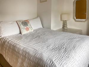 a white bed with a pillow on top of it at Chainbridge Cottage in Whitby