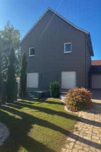 a house with two garage doors on the side of it at Villa Évasion Prestige in Brumath