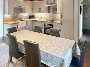 a kitchen with a table with chairs and a counter top at Old Kielder Castle Cottage in Kielder