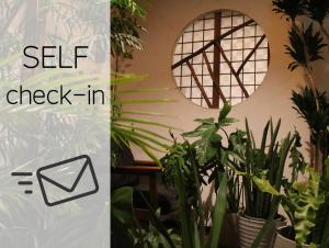 大阪Hostel Caranashi的一间摆满植物的房间，并挂着“自助入住”的标志