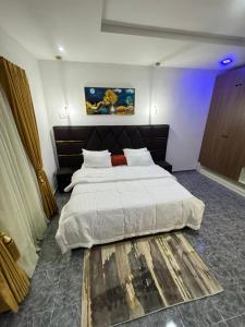 Un dormitorio con una cama grande con sábanas blancas. en CnP luxury 1 bedroom apartment Lekki, en Ikuata