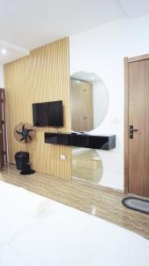 Habitación con TV y pared de madera. en CnP luxury 1 bedroom apartment Lekki, en Ikuata
