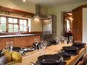una cucina con tavolo in legno e bicchieri da vino di Baker's Cottage a Hotham