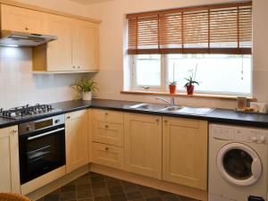 a kitchen with a sink and a dishwasher at Beachcomber Cottage in Woodhorn
