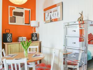 a dining room with an orange wall and a table at Seagulls Studio in Bridlington