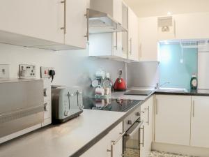 a kitchen with white cabinets and a microwave at Seagulls Studio in Bridlington