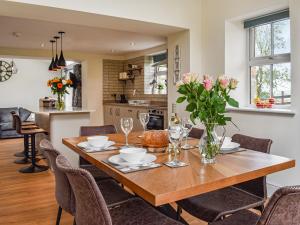une table de salle à manger avec un vase de fleurs dessus dans l'établissement Swiss Cottage, à Scotforth