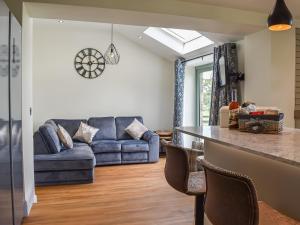 Il comprend une cuisine et un salon doté d'un canapé bleu. dans l'établissement Swiss Cottage, à Scotforth