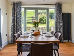 une salle à manger avec une table et des chaises en bois dans l'établissement Swiss Cottage, à Scotforth