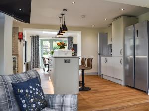 Il dispose d'une cuisine et d'un salon avec une table et un réfrigérateur. dans l'établissement Swiss Cottage, à Scotforth