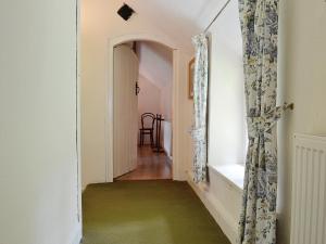 a hallway with a green floor and an open door at Fedwr Gog Cottage in Llangwm +30 photos