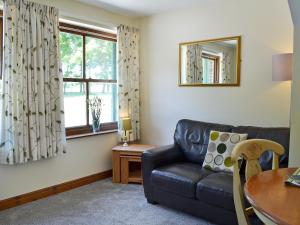 a living room with a couch and a table at Percheron Cottage in Sewerby