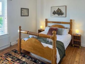 a bedroom with a wooden bed with two night stands at Enginemans Cottage in Bishop Auckland