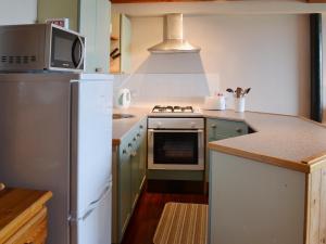 a kitchen with a refrigerator and a microwave at Meadowsweet Cottage - E1496 in Scalby