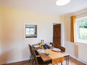 a dining room with a wooden table and chairs at The Lodge At Harvest Farm in Ludlow