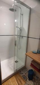 a shower with a glass door in a bathroom at Appartement centre ville in Arbois
