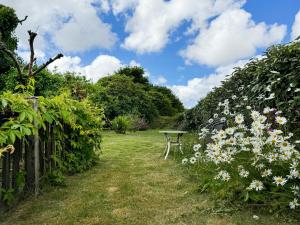 a garden with a table in the middle of flowers at Pencaire in Helston +5 photos