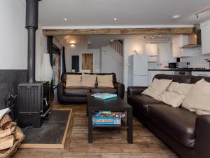 a living room with two couches and a stove at Willow Barn - Fernhill Farm in Wootton Bridge