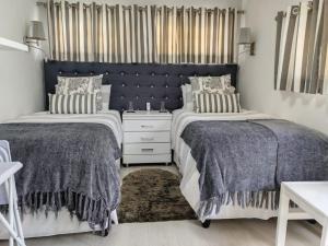 two beds sitting next to each other in a bedroom at Marula Guest House Unit 1 in Durban
