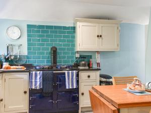 a kitchen with blue tile on the wall at No Place in Penzance