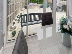 a balcony with a bench and a table and shoes at Coleridge Lodge in Thornton