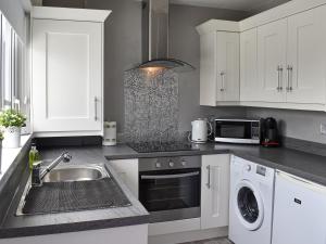 a kitchen with a sink and a dishwasher at Coleridge Lodge in Thornton