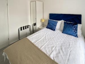 a bedroom with a large bed with blue pillows at Coleridge Lodge in Thornton +13 photos
