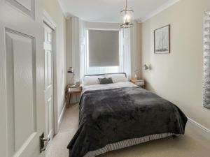 Un dormitorio con una cama con una manta negra. en Admiral's Lookout, en Ilfracombe