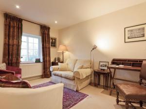 a living room with a couch and a piano at The Gatehouse Cottage in Wells