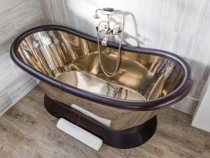 a copper bathtub in a bathroom with a sink at The Gatehouse Cottage in Wells