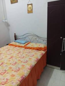 a bed in a bedroom with a clock on the wall at Rumah Inap ABC in Pasir Mas