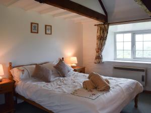 une chambre avec un grand lit blanc avec deux lampes dans l'établissement Cych Cottage, à Capel-Ifan
