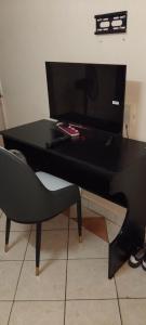 a black desk with a chair and a computer monitor at Studio apartment in Kisumu