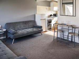 ein Wohnzimmer mit Couch und Küche in der Unterkunft Harley's Beach House in Scratby