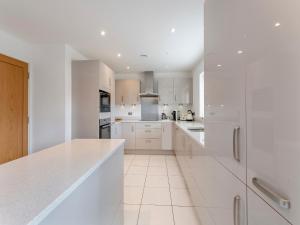 a kitchen with white cabinets and white appliances at Carey in Eastchurch