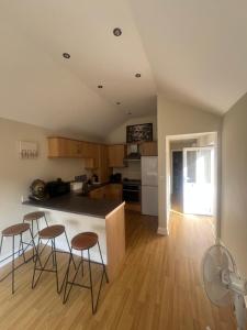 a kitchen with a counter and stools in a room at Open plan flat with large garden close to beach in Bournemouth