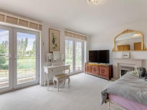 a bedroom with a bed and a desk and a tv at Carey in Eastchurch +20 photos