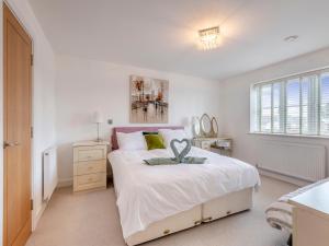 a bedroom with a large white bed and a window at Carey in Eastchurch