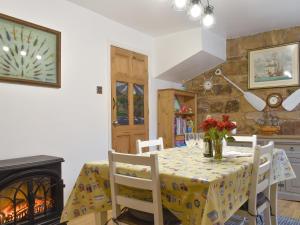 ein Esszimmer mit Tisch und Stühlen und einem Kamin in der Unterkunft Quaker's Cottage in Carlin How