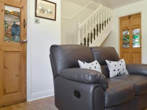 ein Ledersessel mit Kissen darauf in einem Zimmer in der Unterkunft Quaker's Cottage in Carlin How + 21 Fotos