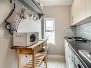 a kitchen with a microwave on a wooden table at Bluebell Apartment - Uk42381 in Bridlington