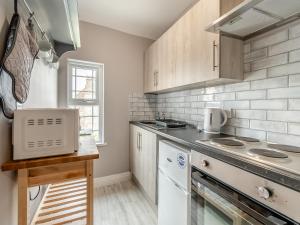 a kitchen with a stove top oven next to a counter at Bluebell Apartment - Uk42381 in Bridlington