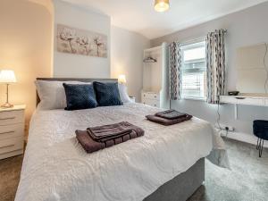 a bedroom with a large bed with two towels on it at Bluebell Apartment - Uk42381 in Bridlington +6 photos