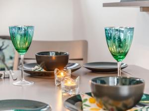 a table with two wine glasses and plates on it at Peacock On The Pin in Stisted