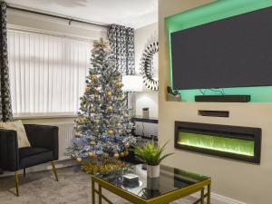 a living room with a christmas tree and a fireplace at Wharfdale Lodge in Thornton