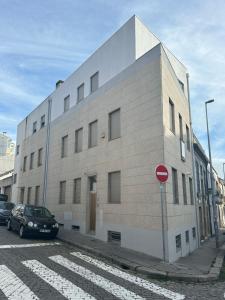 a large white building with a car parked in front of it at Burnay Porto Suites in Porto