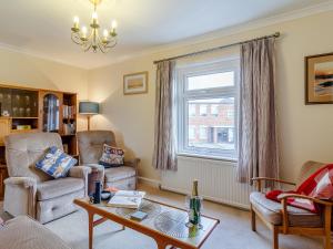 a living room with a couch and a table and a window at Mayflower Cottage in Harwich