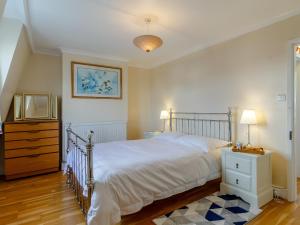 a bedroom with a bed and a dresser and a tv at Mayflower Cottage in Harwich