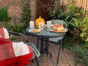 a table with two plates of food on it at Mayflower Cottage in Harwich