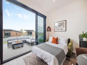 a bedroom with a bed and a large glass window at Lodge One - Uk42796 in Llangefni